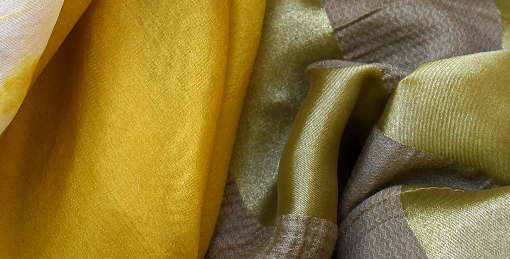 Echarpes de seda tingidas com macela mostrando as cores amarela e verde dependendo do mordente utilizado.