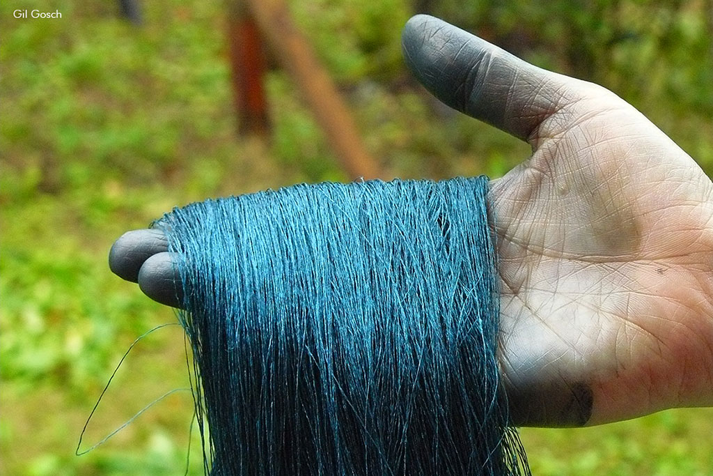 Close dos fios de seda tingidos com azul profundo do índigo